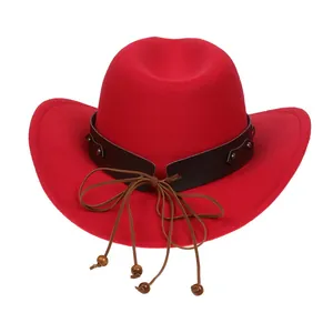 Detail of red cowboy hat featuring studded leather band and decorative wooden beads