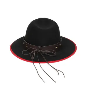 Dettaglio cappello in feltro nero con tesa rossa a contrasto e fascia in pelle borchiata