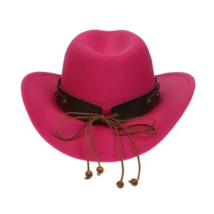 Detail of rose red felt cowboy hat featuring leather band with metal studs and wooden beads