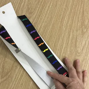 Detail of black elastic suspenders featuring colorful mustache patterns and metal clips