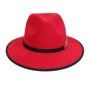Dettaglio cappello fedora rosso con bordo nero e fibbia in metallo dorato decorativa