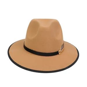 Dettaglio ravvicinato di cappello in lana kaki con foglia dorata e nastro nero decorativo