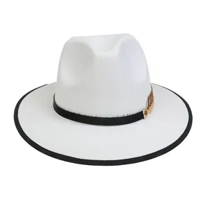 Dettaglio cappello fedora bianco con bordo nero e decorazione piuma dorata vintage