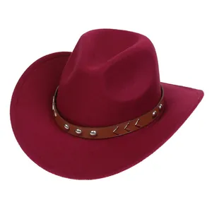 Close-up of wine red felt cowboy hat with brown leather band and silver metal studs