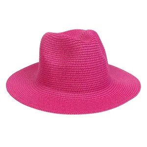 Detailed weave texture of a vibrant hot pink wide brim straw sun hat for summer