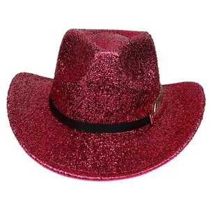 Detail of glittery magenta cowboy hat featuring black ribbon and golden feather buckle