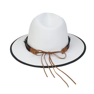 Dettaglio di cappello fedora bianco con fascia in cuoio marrone e decoro testa di toro