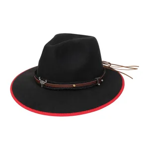 Dettaglio cappello western in feltro con stemma testa di toro e bordo rosso