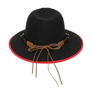 Dettaglio macro del cappello di lana nero con bordo rosso e fascia in pelle decorativa