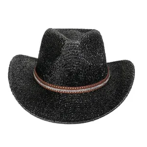 Détail d'un chapeau de cowboy noir avec bande en cuir brun, strass et rivets dorés