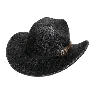 Détail d'un chapeau de cowboy en paille noire avec plume dorée métallique sur bande cuir