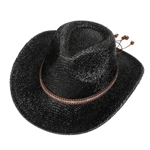 Détail d'un chapeau de cowboy noir tressé avec ruban marron, clous argentés et perles en bois