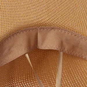 Detailed macro view of the inner sweatband and adjustable drawstring of a straw sun hat