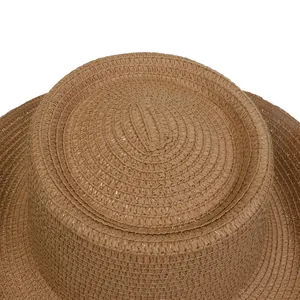 Primer plano detallado de la textura tejida y la copa plana de este sombrero de paja