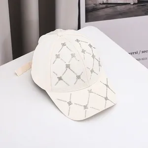 Détail d'une casquette en coton beige avec des motifs grillagés en strass trèfle