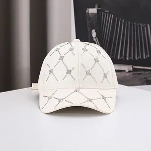 Détail d'une casquette crème avec grille en strass et motifs trèfles brillants