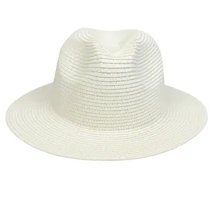 Klassischer weißer Strohhut mit Fedora-Krone und breiter Krempe für den Sommer am Strand