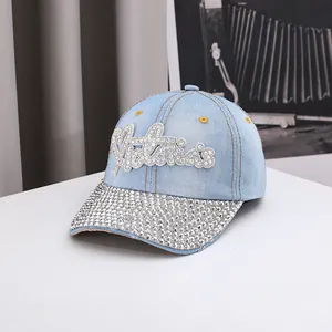 Detail of light blue denim baseball cap with sparkling rhinestones on the brim and crown