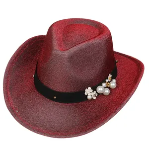 Dettaglio del cappello da cowboy rosso glitterato con perle e fiori sul nastro nero