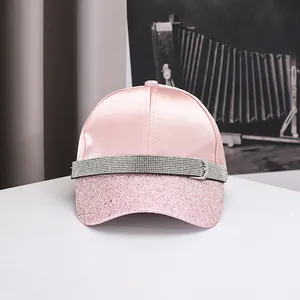 Detailed view of pink satin baseball cap with glittering sequins and rhinestone strap