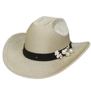 Dettaglio di cappello cowboy glitter champagne con nastro floreale e perle bianche