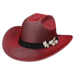 Dettaglio di cappello da cowboy rosso glitterato con nastro nero e perle eleganti