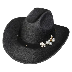 Dettaglio di cappello da cowboy nero glitterato con perle e fiori bianchi decorativi