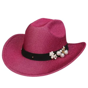 Dettaglio di cappello da cowboy fucsia glitterato con perle bianche e fiori