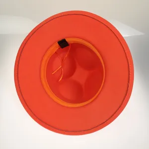 Interior view of orange wool fedora showing adjustable strap and 65% cotton fabric label