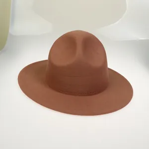 Detail of caramel brown wool fedora with flat brim and classic indented crown texture