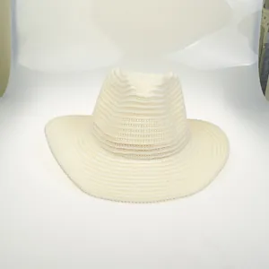 Macro detail of creamy white woven straw cowboy hat showing dense spiral texture