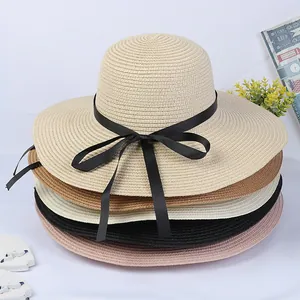 Foldable wide brim straw beach hats for women featuring stylish black ribbon bow decorations