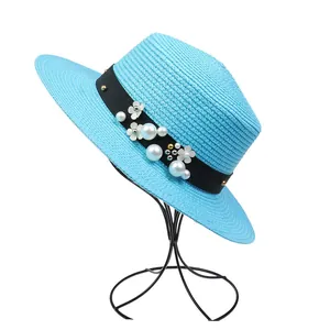 Detail of bright blue boater hat with pearls, floral ornaments, and ribbon
