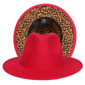 Dettaglio cappello fedora rosso a tesa larga con sotto-tesa leopardato ed etichetta