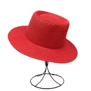 Detailed macro view of the bright red straw boater hat weave on a black metal display stand