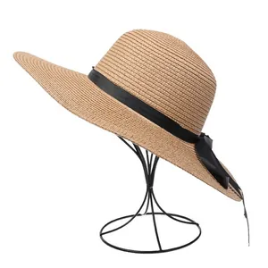 Detailed view of the straw hat's weave texture and elegant black ribbon bow decoration