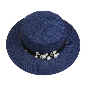Top view of navy straw hat with decorative faux pearls and floral embellishments