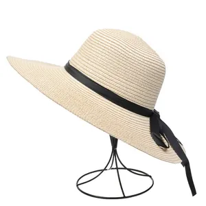 Close-up of wide-brim straw sun hat with black ribbon bow and fine woven texture
