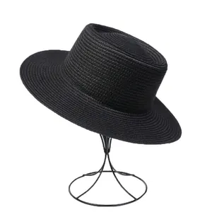 Close-up of black straw sun hat with fine woven texture and flat brim structure