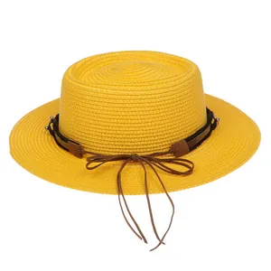 Detail von gelbem Strohhut mit braunem Lederband und zarter Schleife für den Sommer