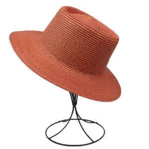 Close-up of the spiral woven texture on a red-brown straw hat on a display stand