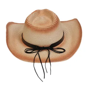 Detalle de sombrero de vaquero en paja tejida con degradado y cinta decorativa negra
