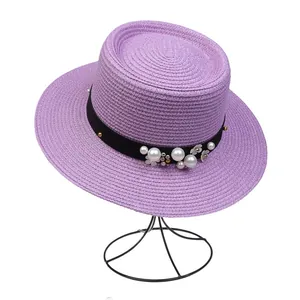 Detailed shot of lavender straw hat with elegant pearls and white flower decorations