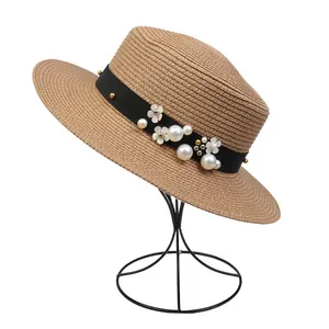 Detailed texture of khaki woven straw hat with elegant pearls and floral embellishments