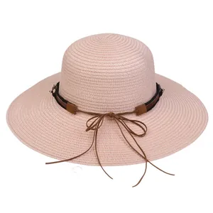 Detail of pink woven straw sun hat showing fine texture and brown leather铆钉 ribbon band