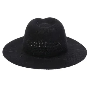 Detail of black woven straw hat featuring breathable hollow-out design and wide brim