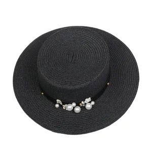 Detailed view of black straw hat featuring elegant pearl and white flower embellishments
