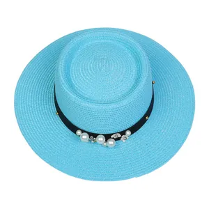 Detail of sky blue boater hat featuring elegant pearl accents and white floral decorations