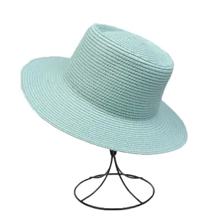 Detail of light blue straw boater hat featuring fine woven texture and flat brim