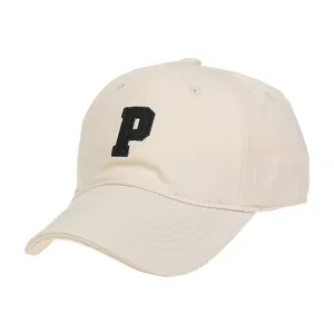 Primer plano de gorra beige con bordado negro de la letra P y ojales de ventilación